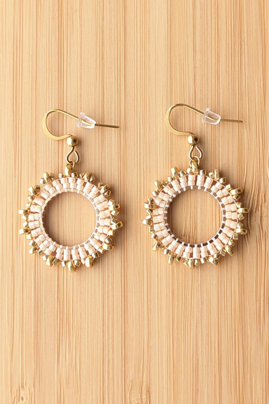 boucles d'oreilles en perles marron clair sur fond bois