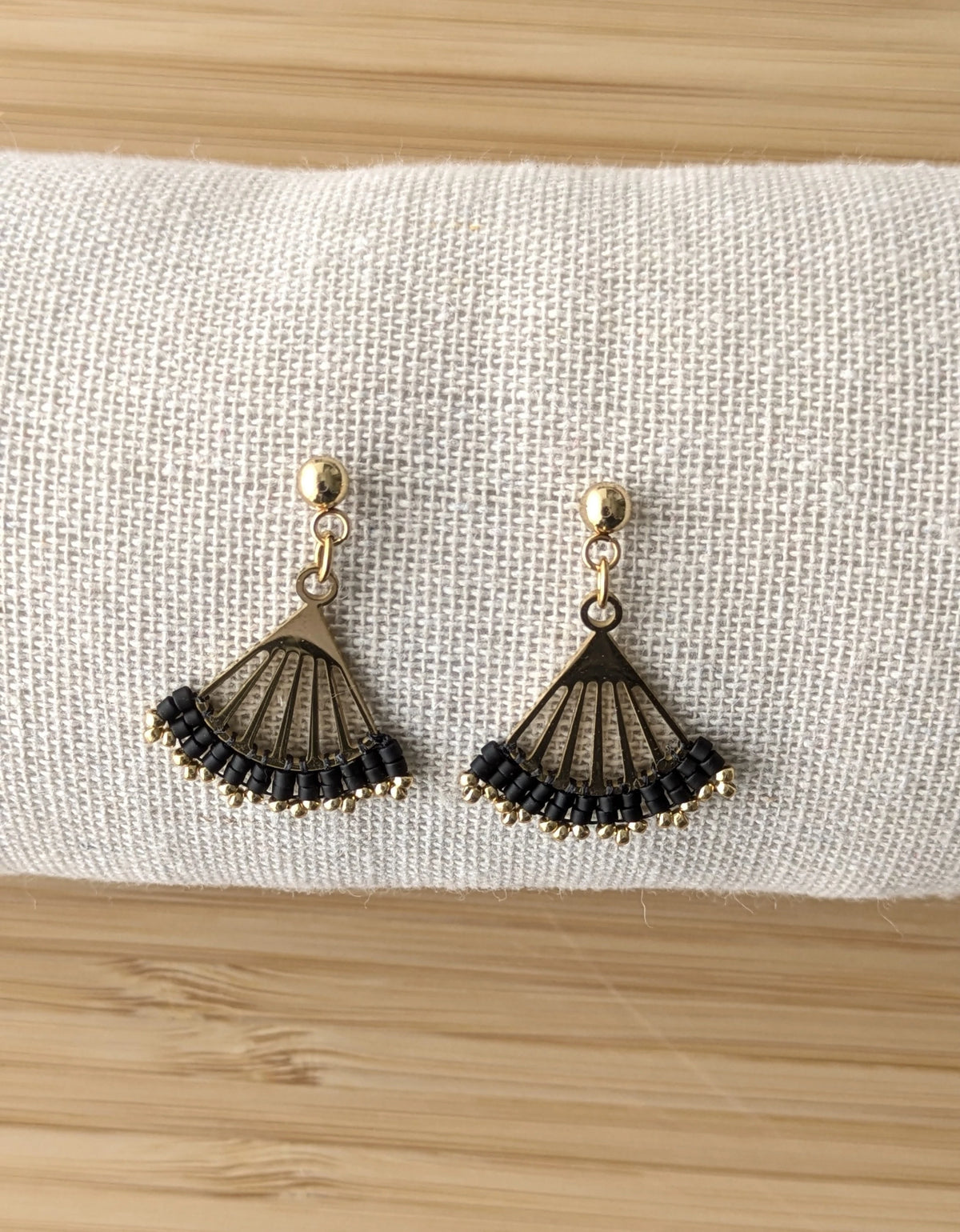 Clous d'oreilles Lola en perles noires- Présentées de face sur coussin