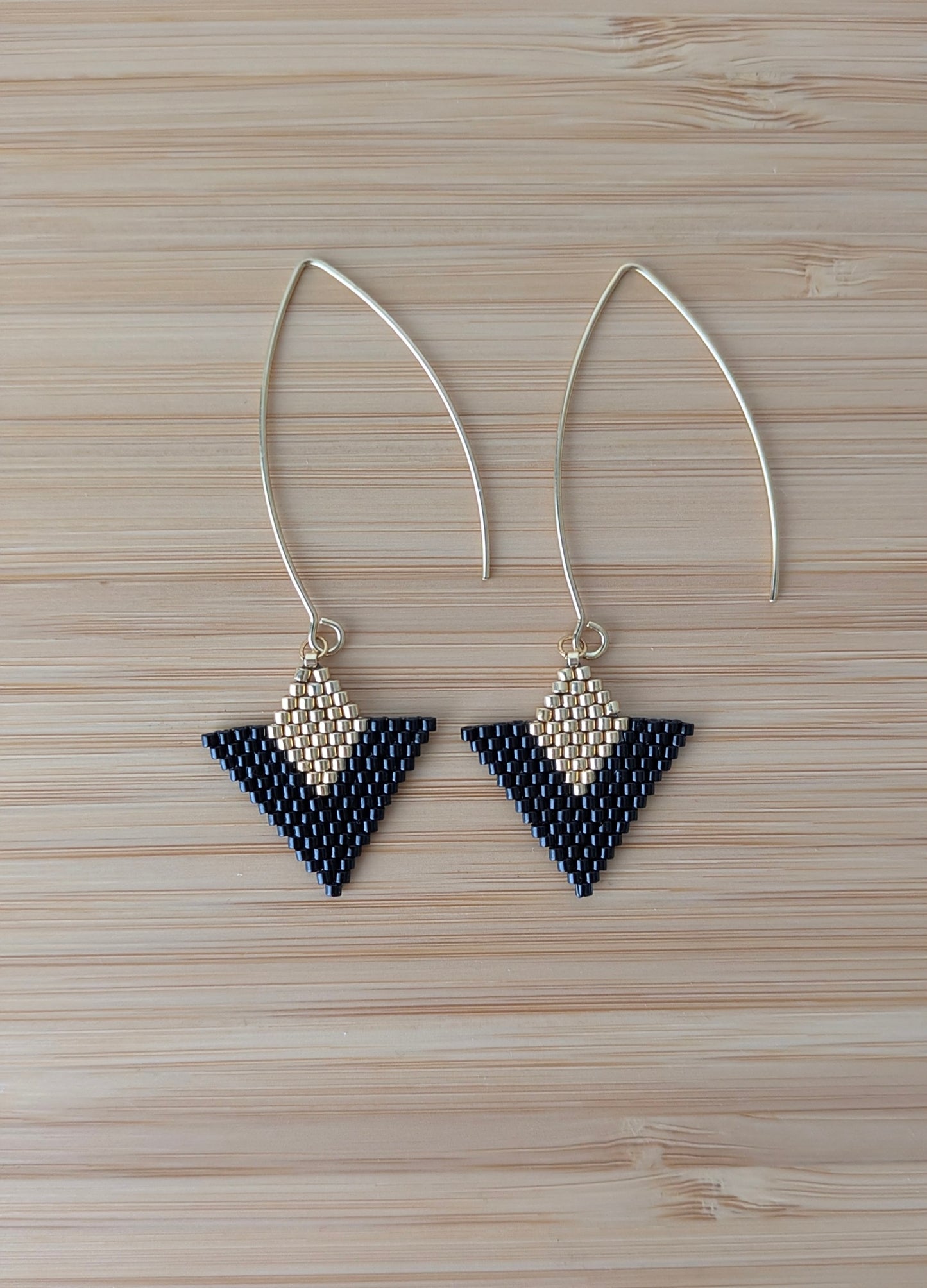 Vue détaillée des boucles artisanales en perles miyuki noires et dorées