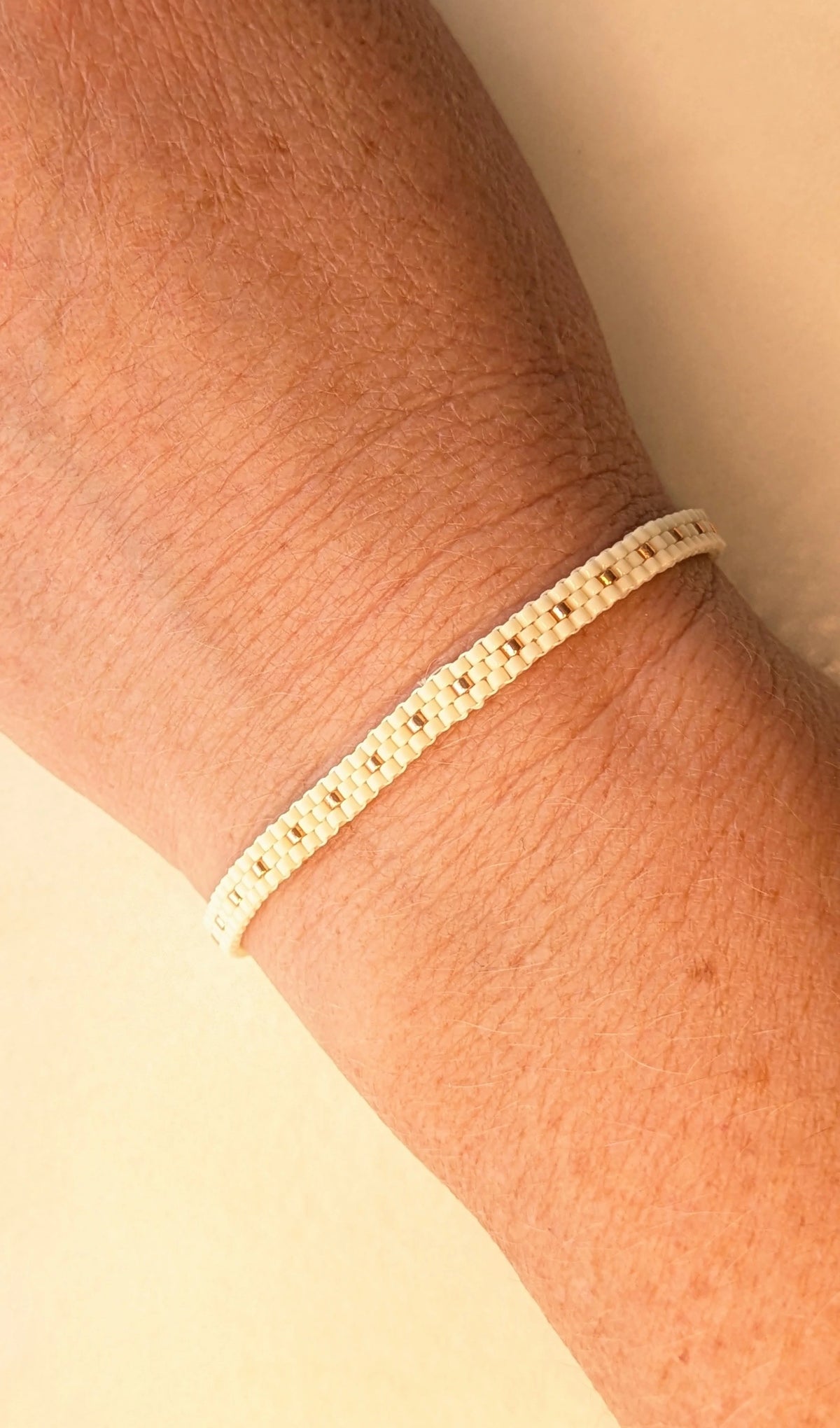 bracelet en perles tissées couleur crème porté