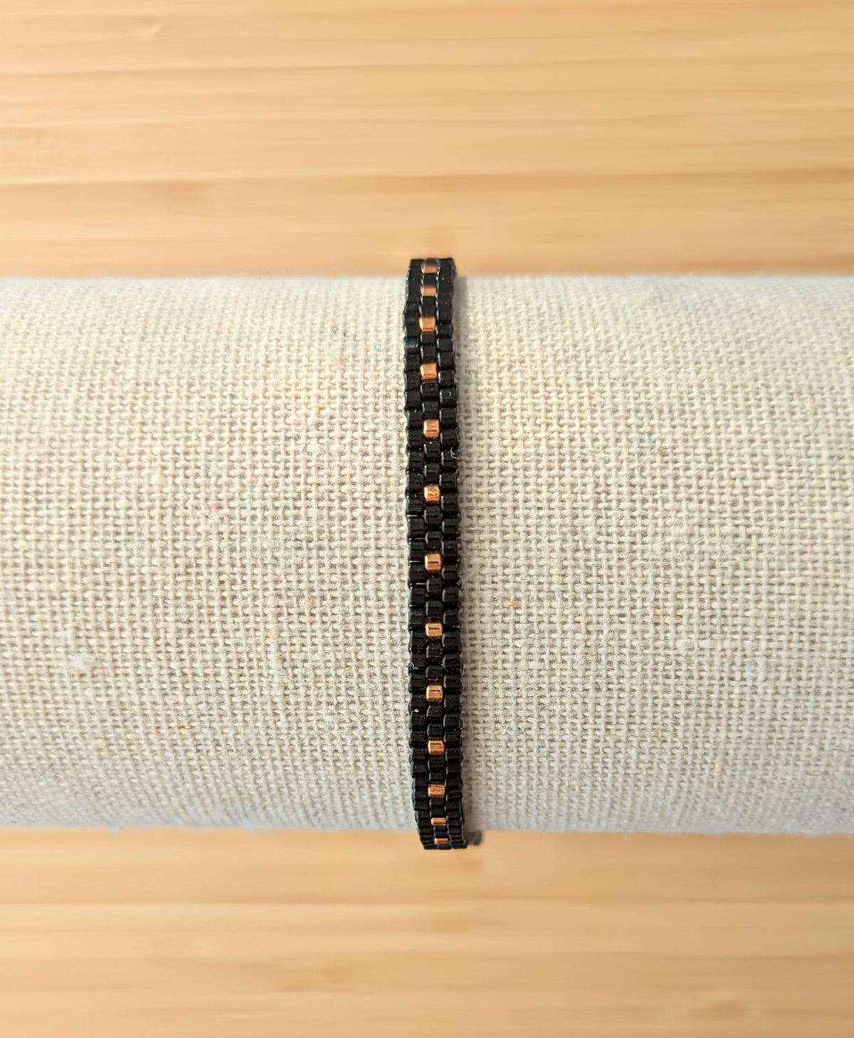 Bracelet tissé main en perles noires sur présentoir