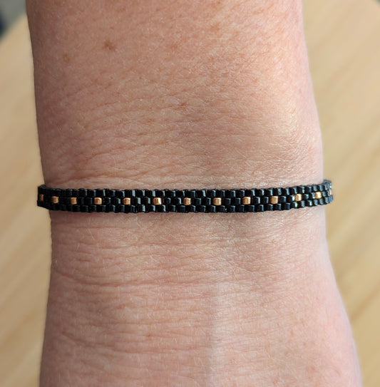 Bracelet fin en perles miyuki noires et cuivrées- Vue porté sur poignet femme