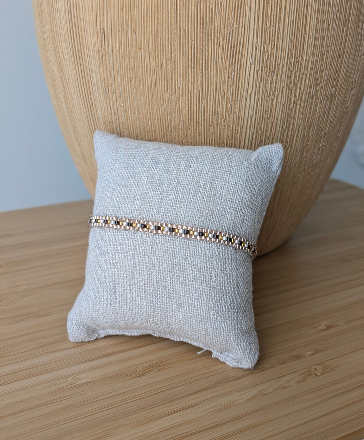 Bracelet Zoé noir et jaune doré présenté sur un coussin