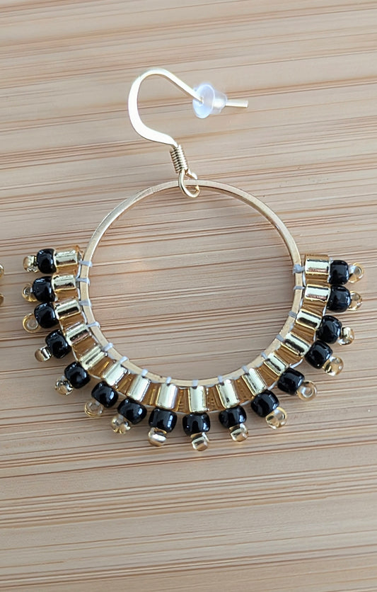 Détail du tissage de perles Miyuki noires et dorées