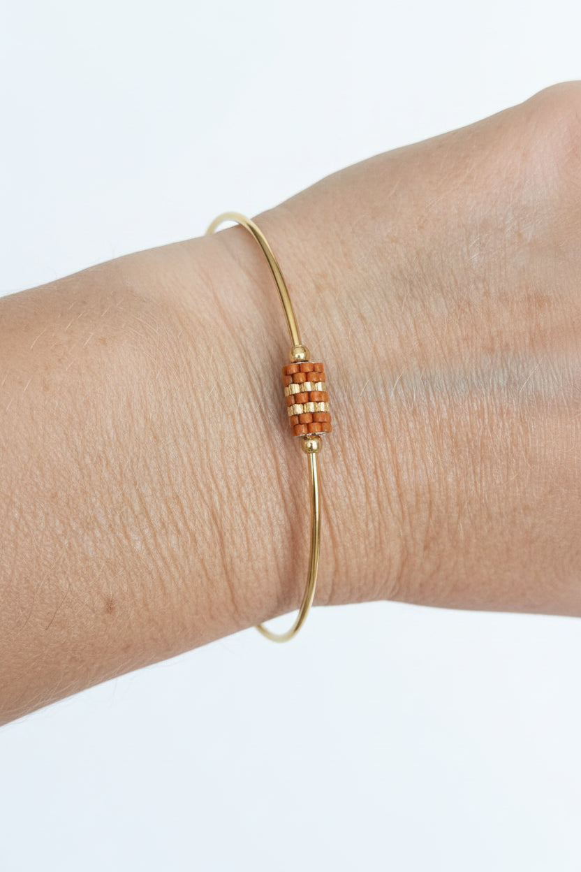 Jonc doré orné d'un tissage de perles Miyuki terracotta - Bijou porté sur poignet féminin