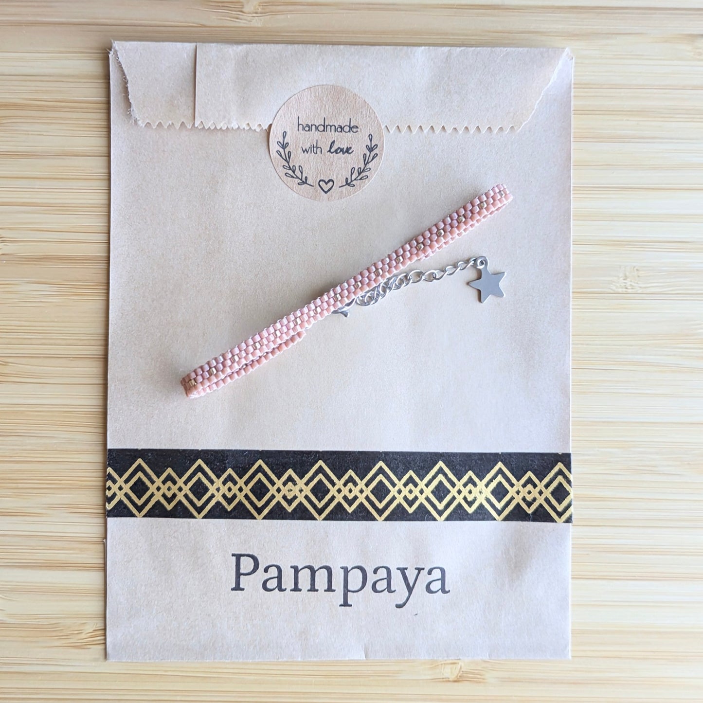 bracelet tissé en perles miyuki roses posé sur emballage Pampaya avec sticker "Handmade with love"