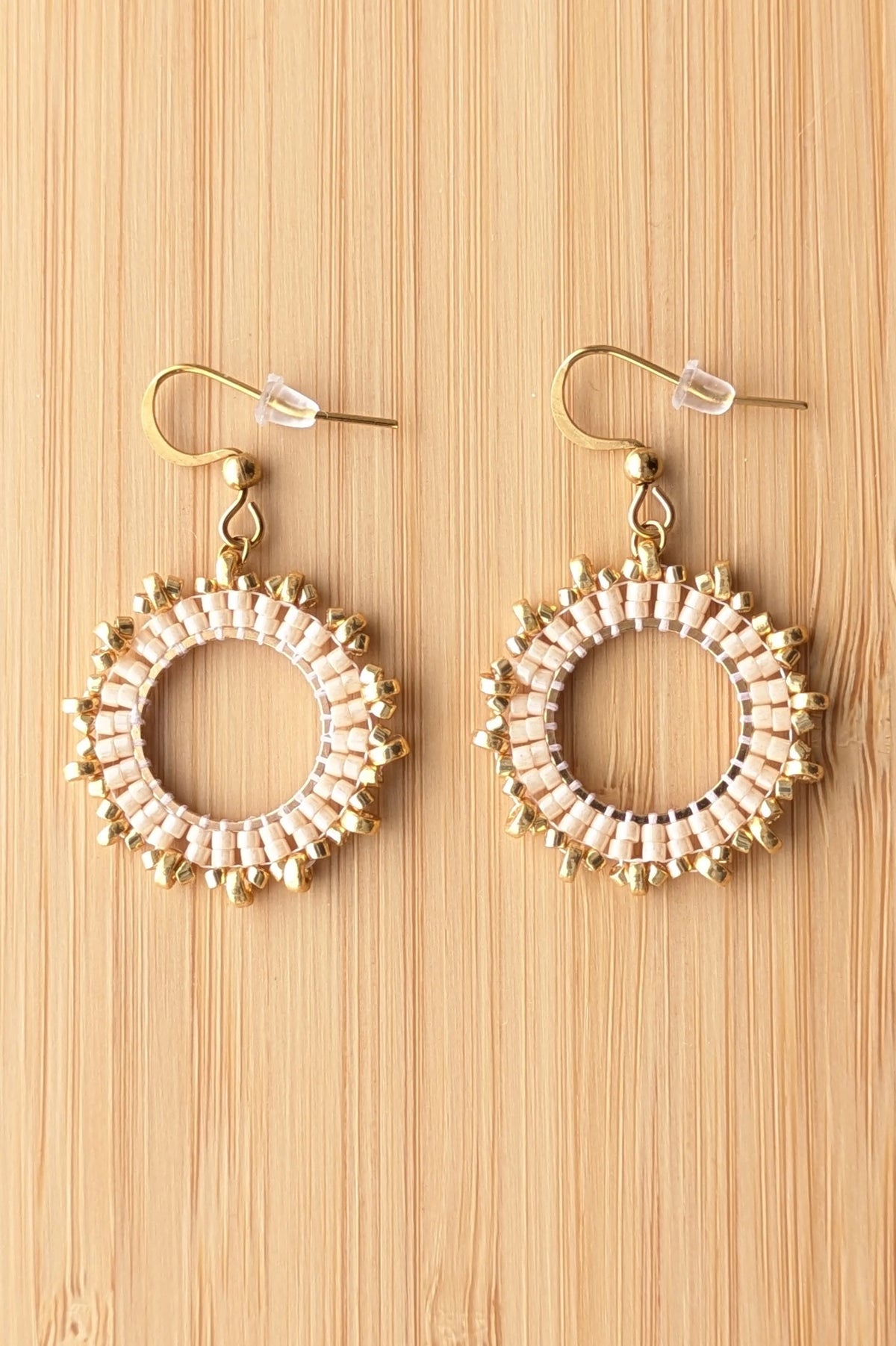boucles d'oreilles en perles marron clair sur fond bois