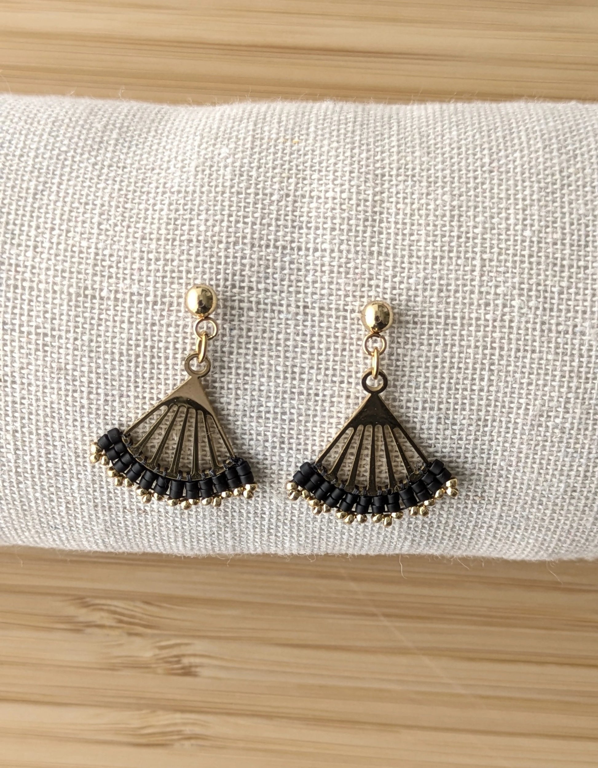 Clous d'oreilles Lola en perles noires- Présentées de face sur coussin