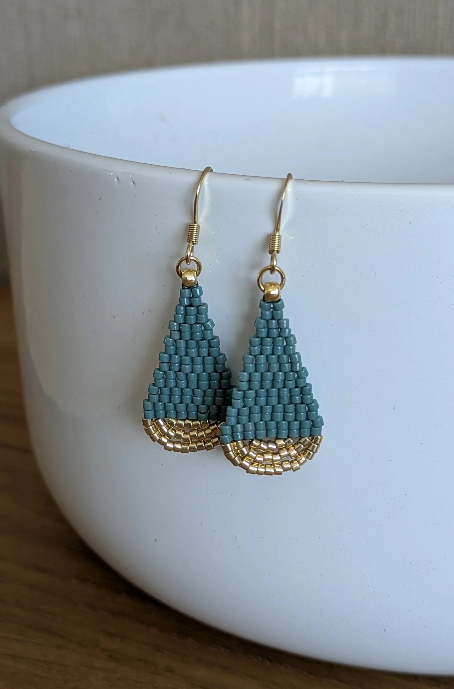 Boucles d'oreilles suspendues sur une coupelle blanche- Mise en valeur des couleurs bleu vert