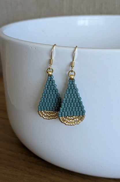 Boucles d'oreilles suspendues sur une coupelle blanche- Mise en valeur des couleurs bleu vert