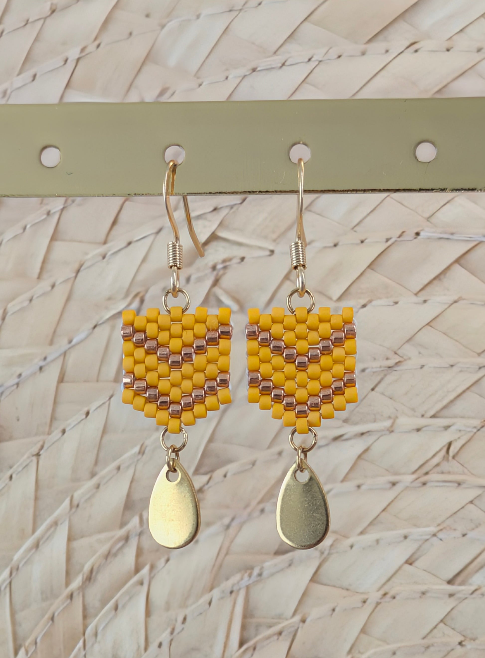 Gros plan sur boucles tissage peyote de perles jaunes et cuivrées