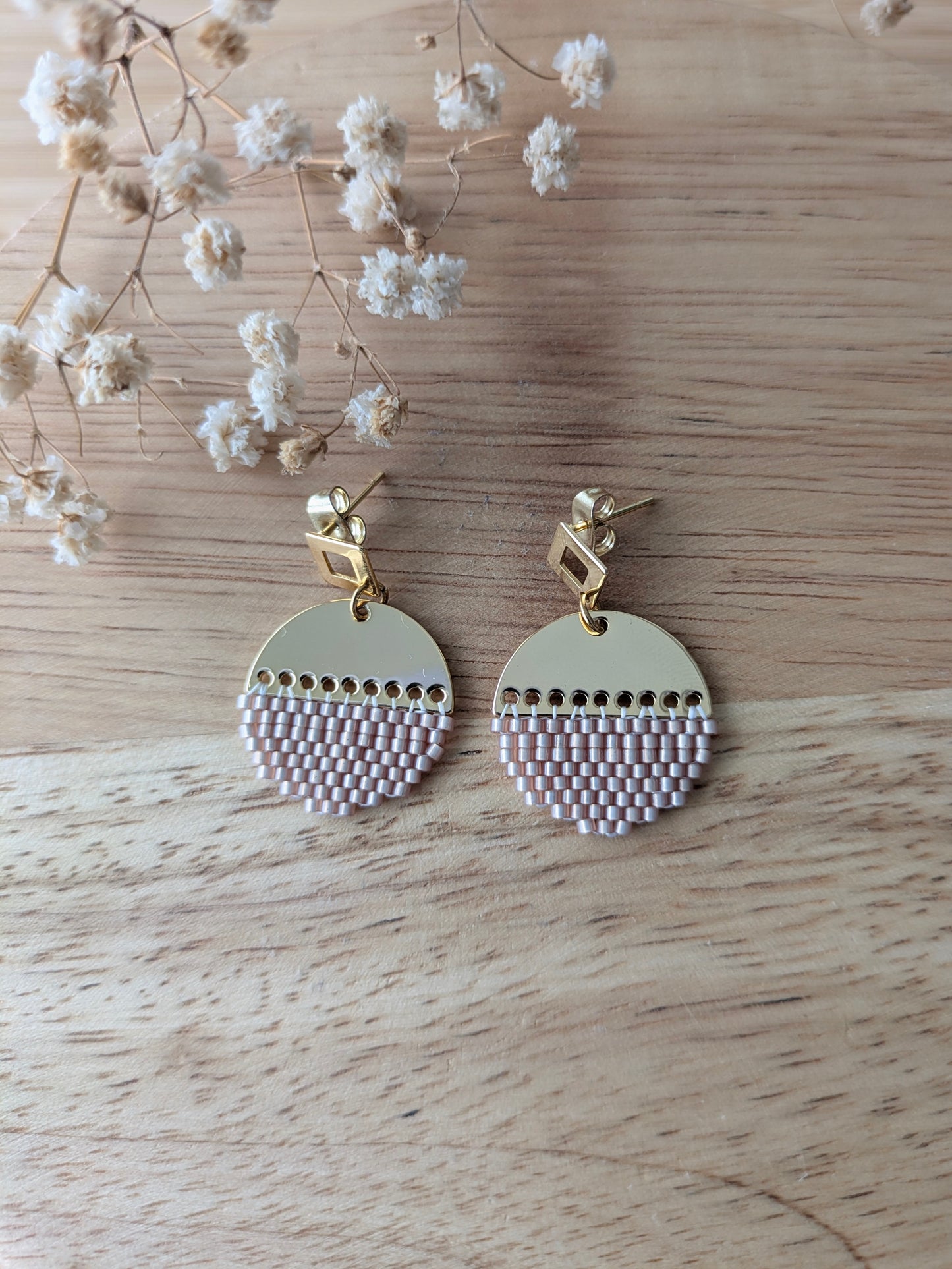 Vue de haut des boucles LUNA en tissage brickstitch présentées à plat sur du bois