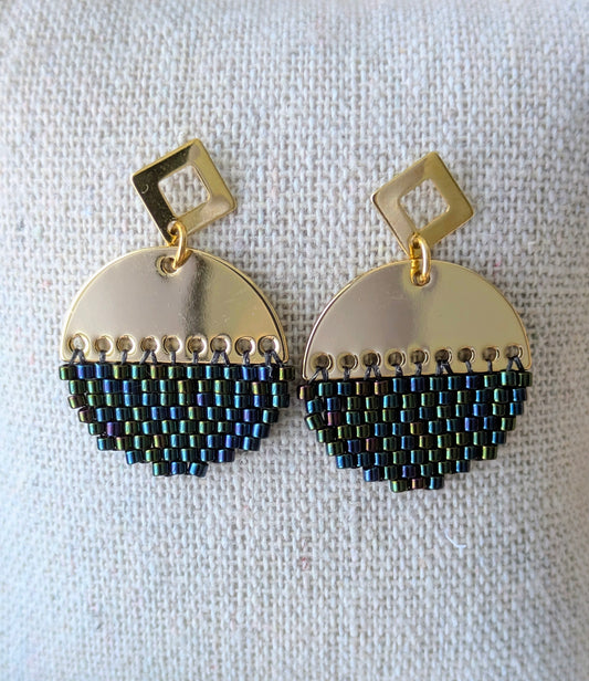 Gros plan sur les boucles rondes en perles tissées avec reflets bleus et verts irisés.