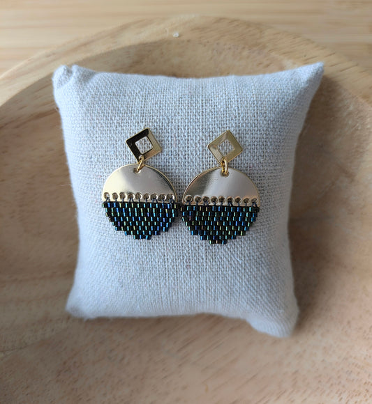 Boucles d'oreilles rondes en perles tissées sur connecteur demi-lune doré présentées sur un coussin