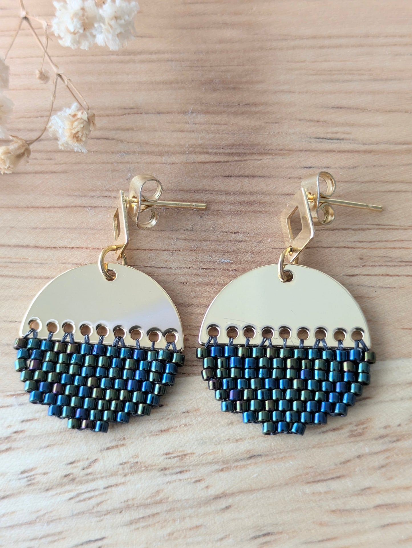 Vue détaillée des boucles en tissage brickstitch sur connecteur demi-lune. Couleur bleu et vert avec des reflets irisés.