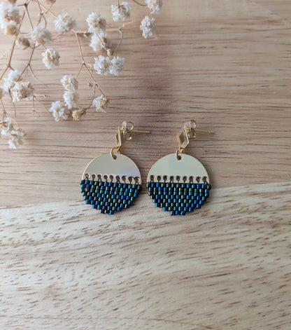 Vue de haut des boucles d'oreilles tissées en perles bleues et vert irisé