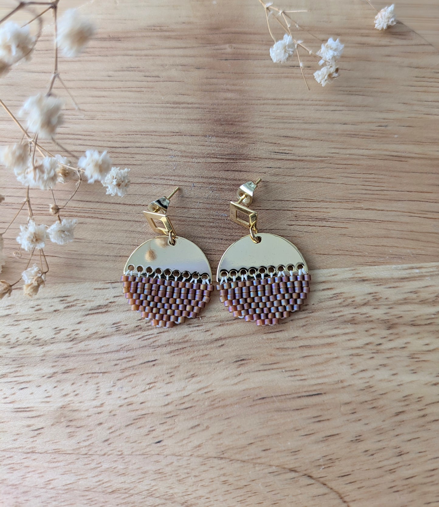 Vue détaillée des boucles en perles rouges à plat sur du bois