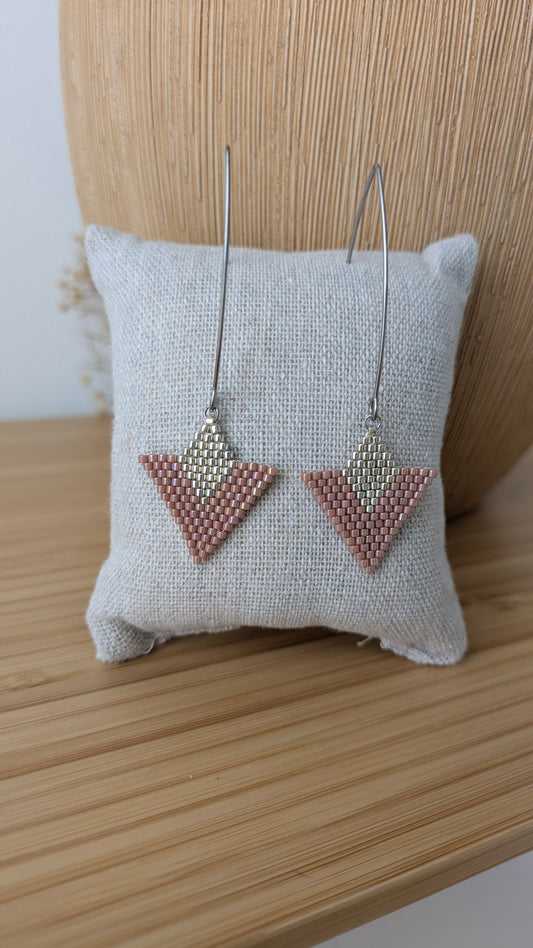 Boucles tissées main en perles roses et argentées présentées sur un coussin