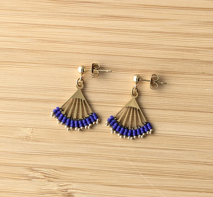 Boucles Lola bleues posées à plat sur du bambou