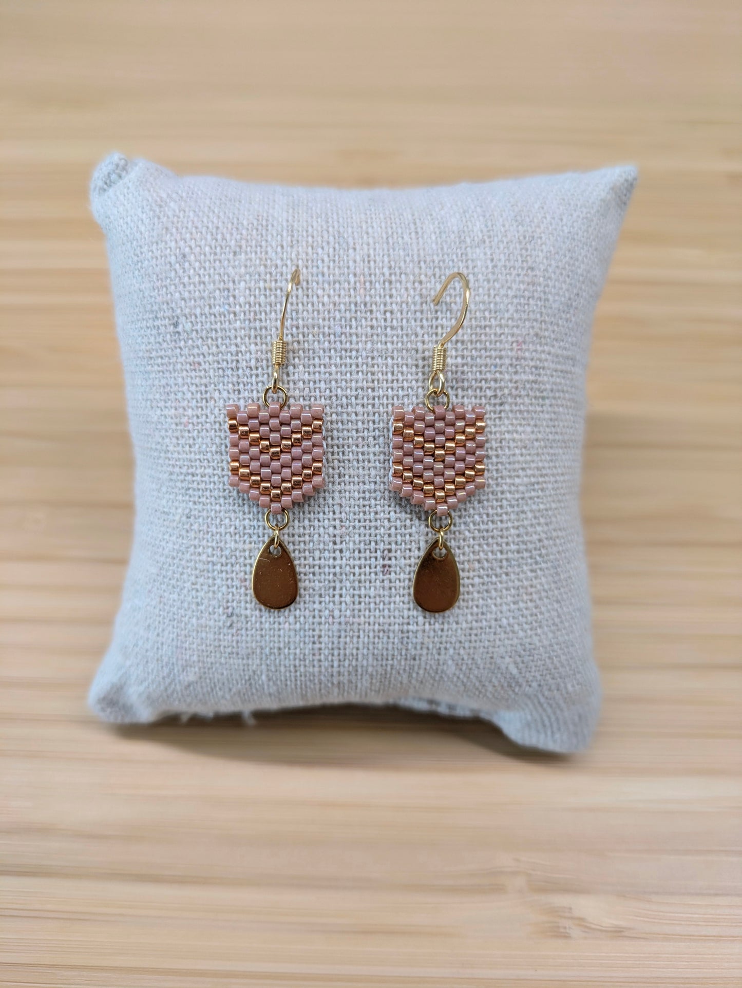 Boucles d'oreilles Fanny en perles tissées roses présentées sur coussin