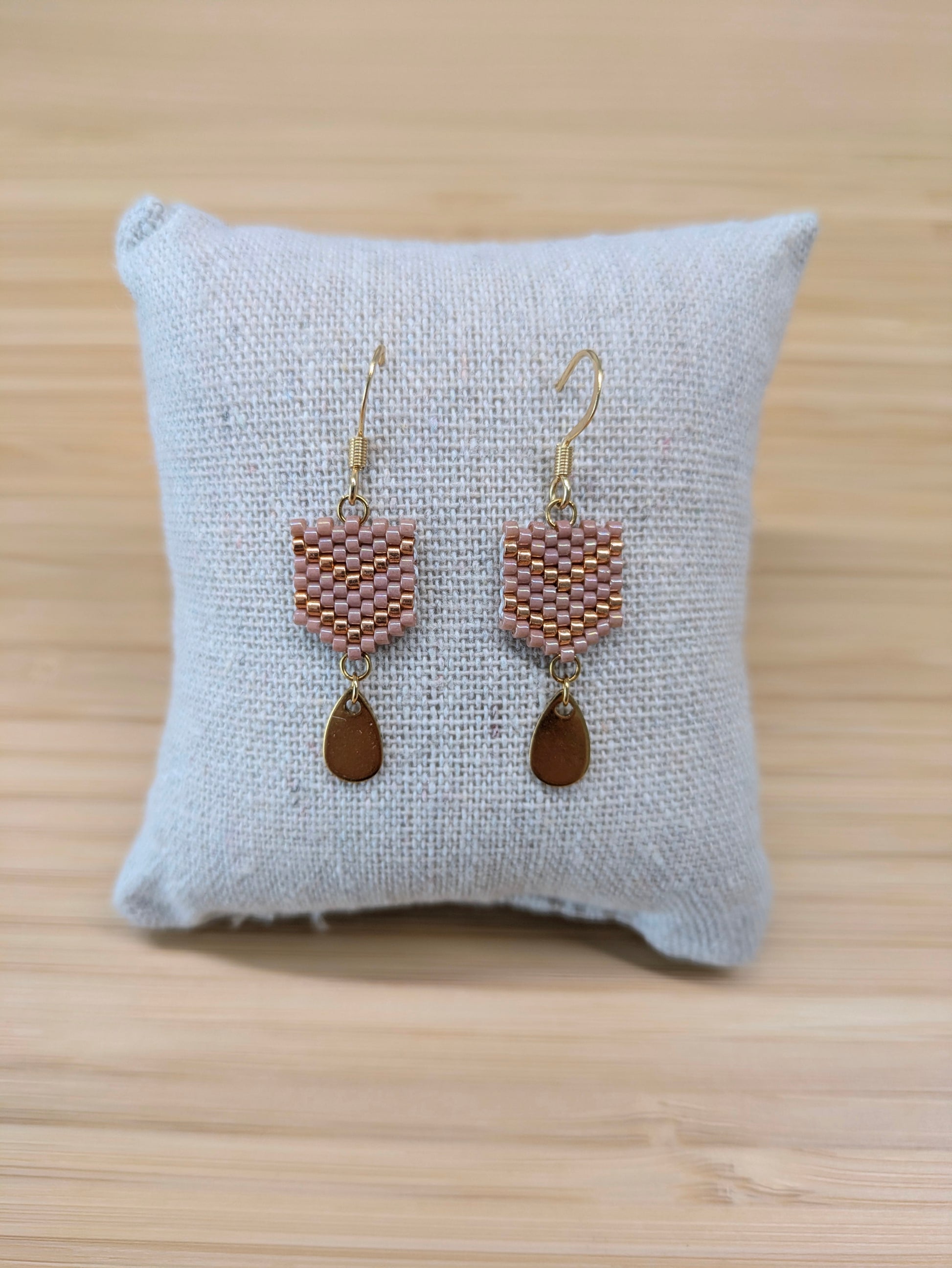 Boucles d'oreilles Fanny en perles tissées roses présentées sur coussin