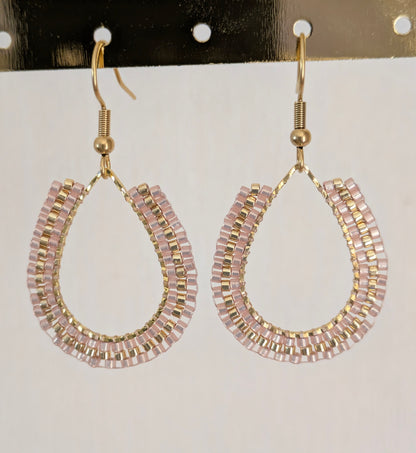 Boucles d'oreilles perlées beiges. Vue détaillée du tissage sur anneau doré en forme de goutte.