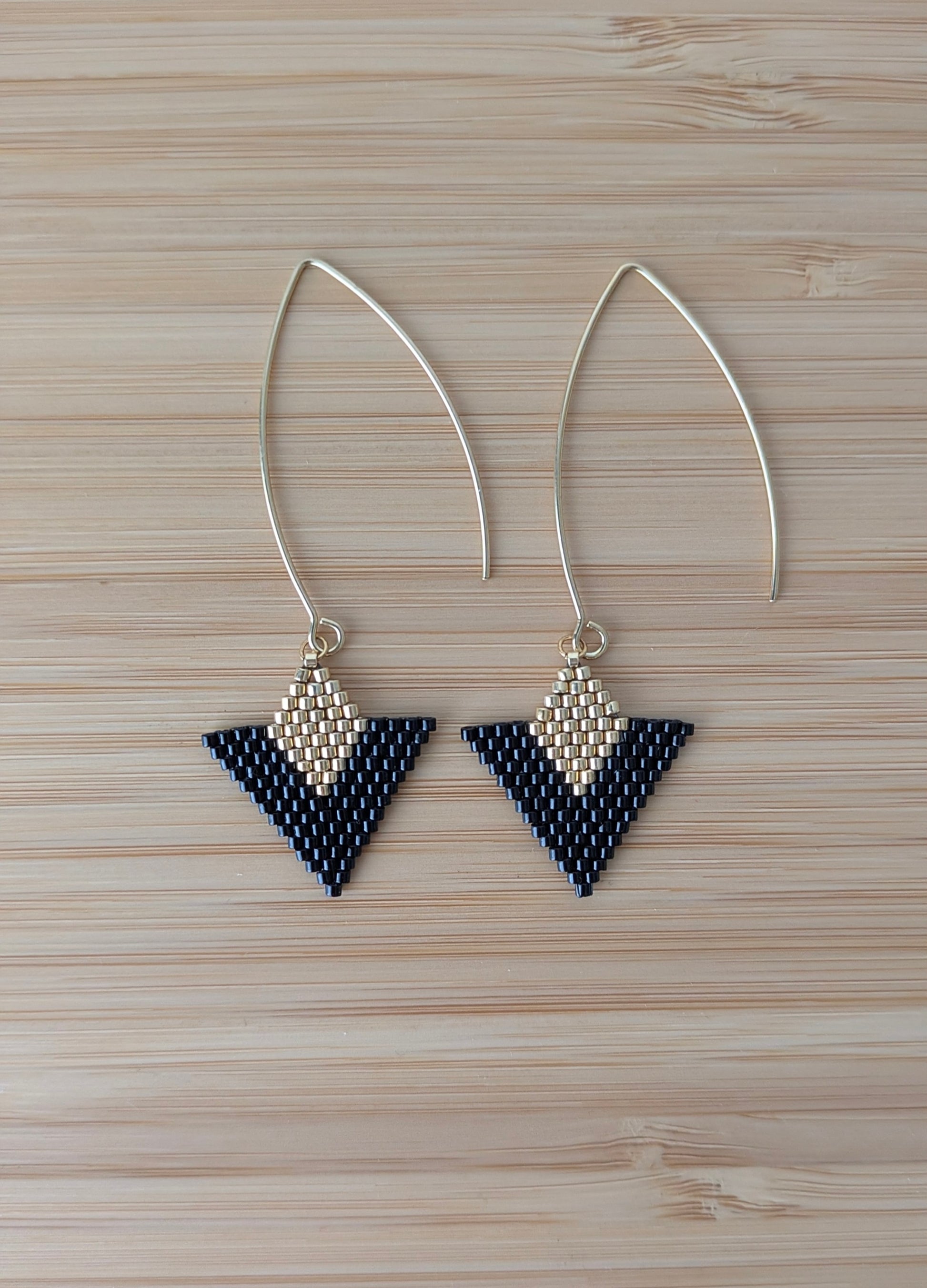 Vue détaillée des boucles artisanales en perles miyuki noires et dorées