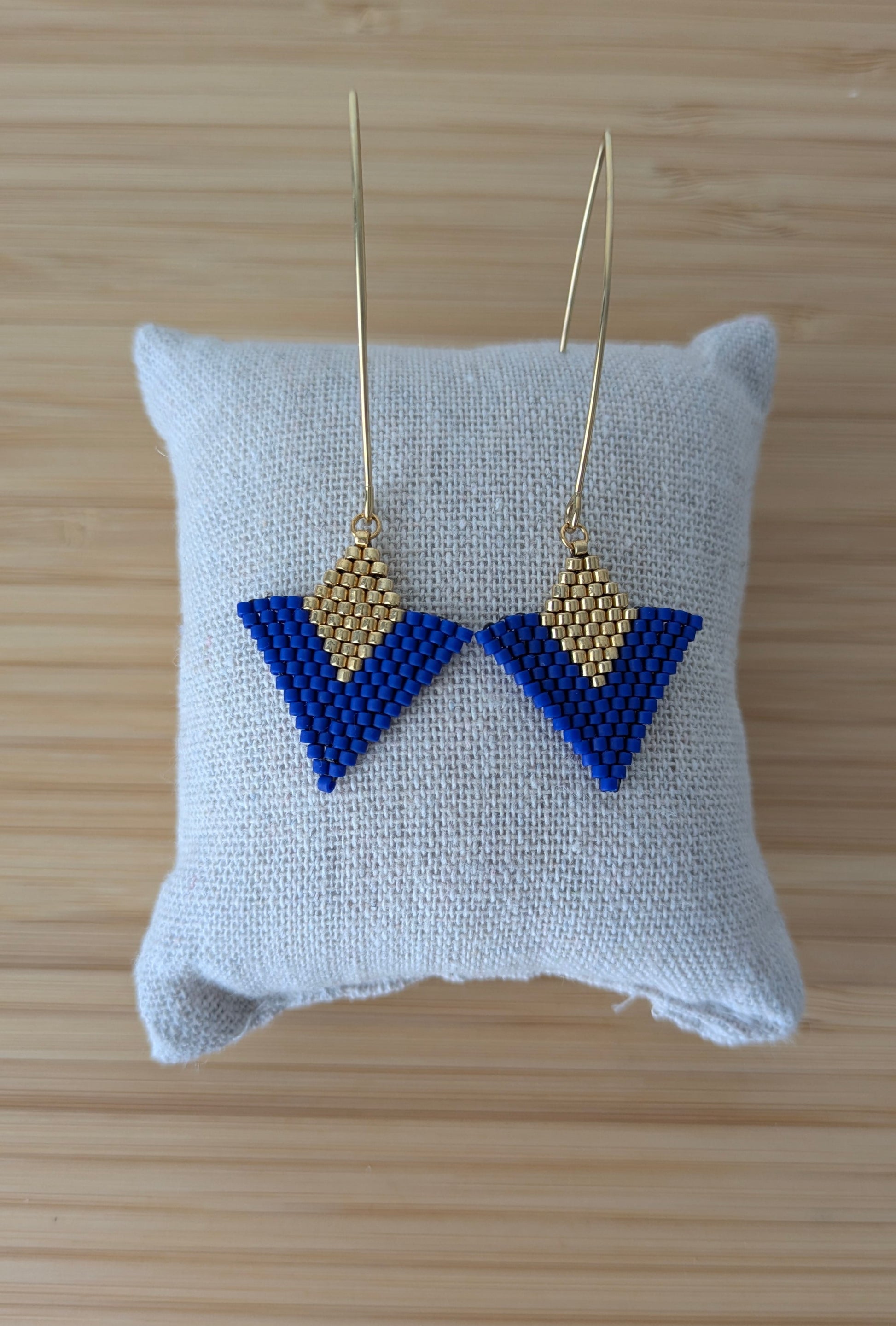 Vue détaillée du tissage brickstitch des boucles graphiques bleues et dorées