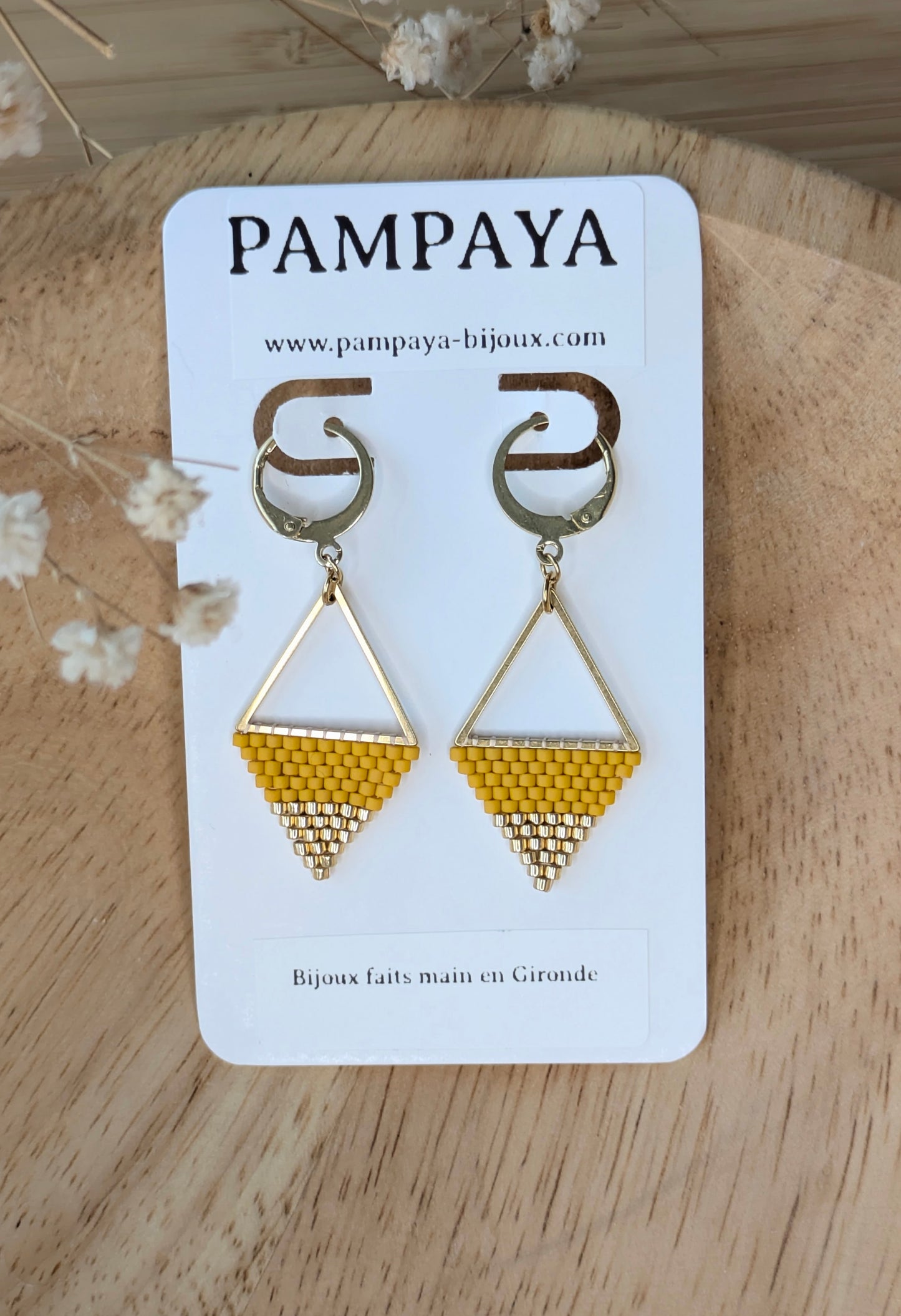 Boucles d'oreilles en perles tissées sur carton présentoir indiquant "Pampaya-bijoux faits main en gronde" 