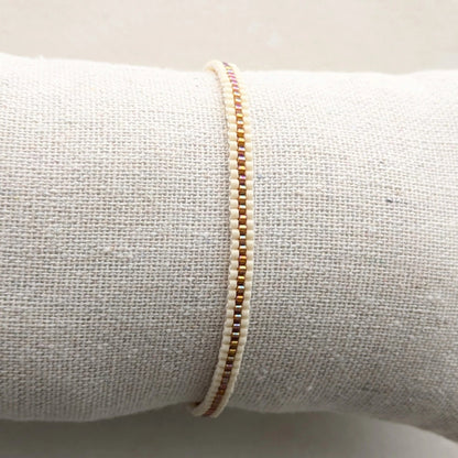 Bracelet tissé en perles présenté sur coussin gris