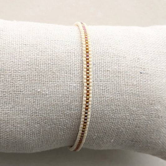 Bracelet tissé en perles présenté sur coussin gris