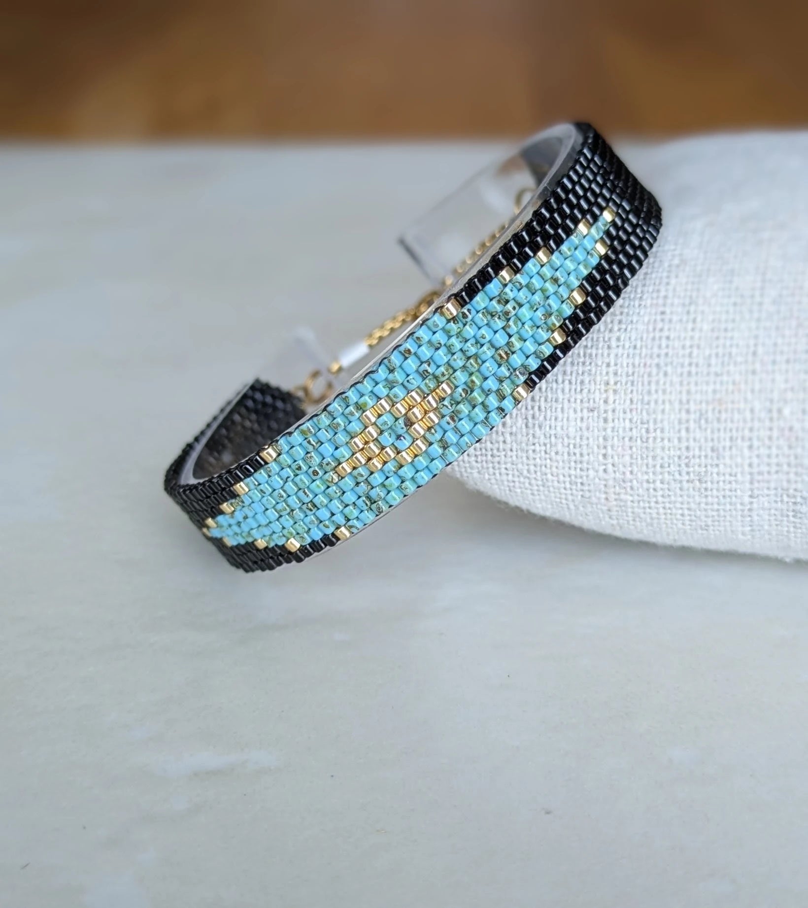 Bracelet tissé présenté de biais sur coussin