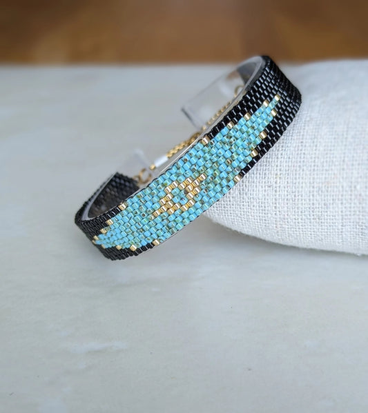 Bracelet tissé présenté de biais sur coussin