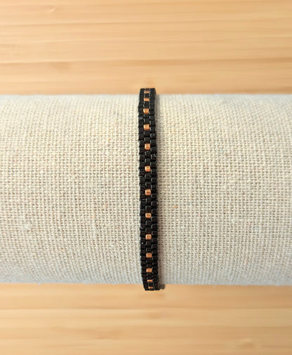 Bracelet tissé main en perles noires sur présentoir