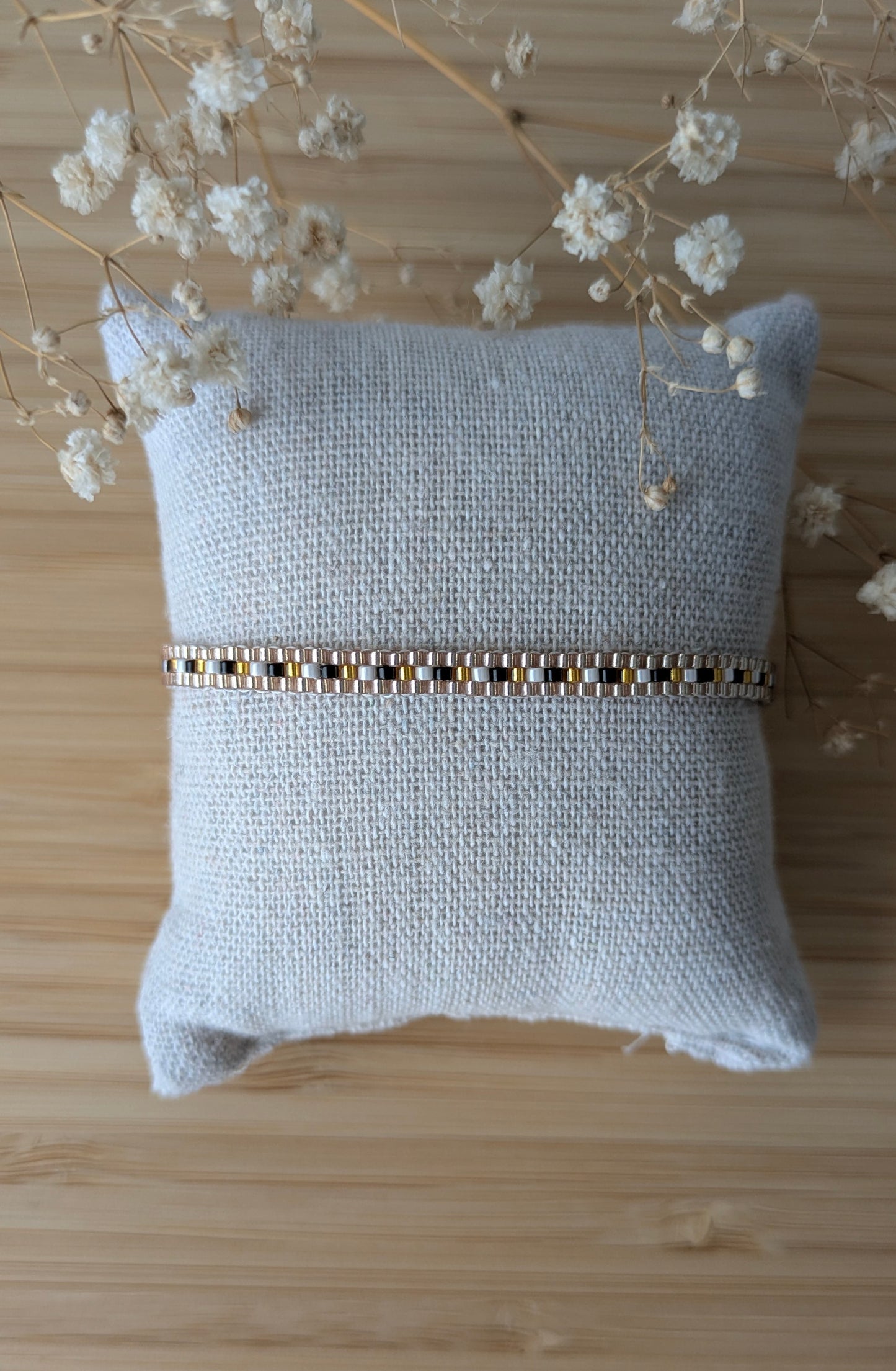Bracelet ZOÉ tissé fin noir et doré sur coussin - bijou artisanal bohème