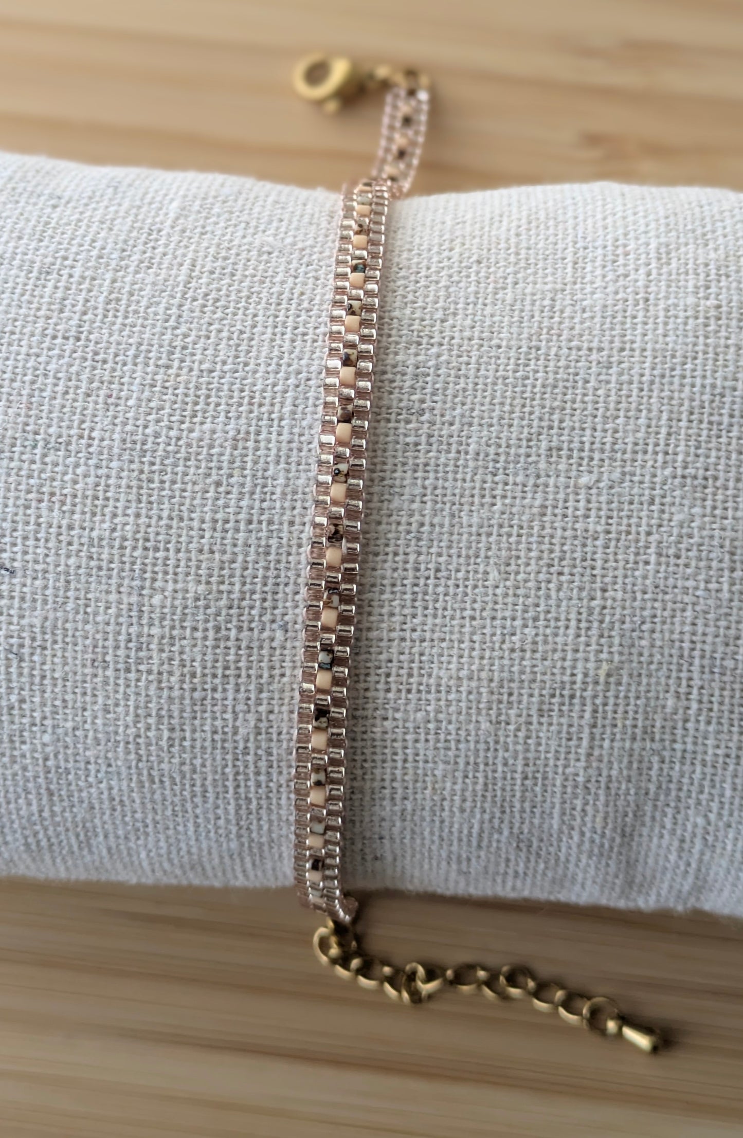 Vue d'ensemble du bracelet tissé en perles marron avec fermoir et chaine d'extension en acier inoxydable doré
