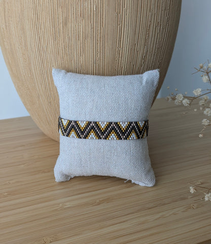 Bracelet Zélie en perles miyuki noires présenté sur un coussin