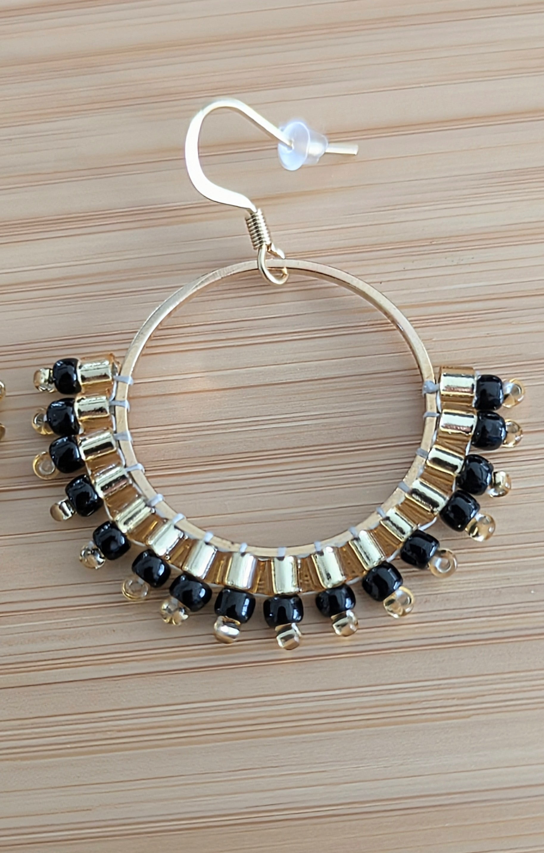 Détail du tissage de perles Miyuki noires et dorées