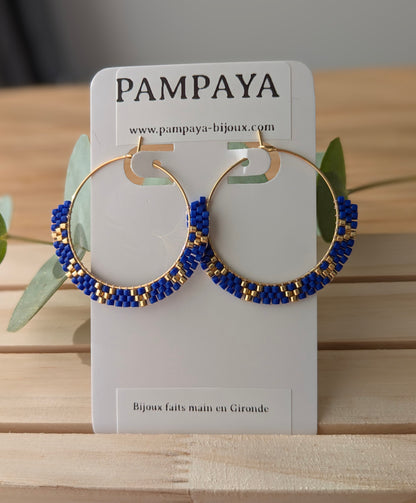 Créoles bleues et dorées en perles tissées à la main sur présentoir Pampaya bijoux