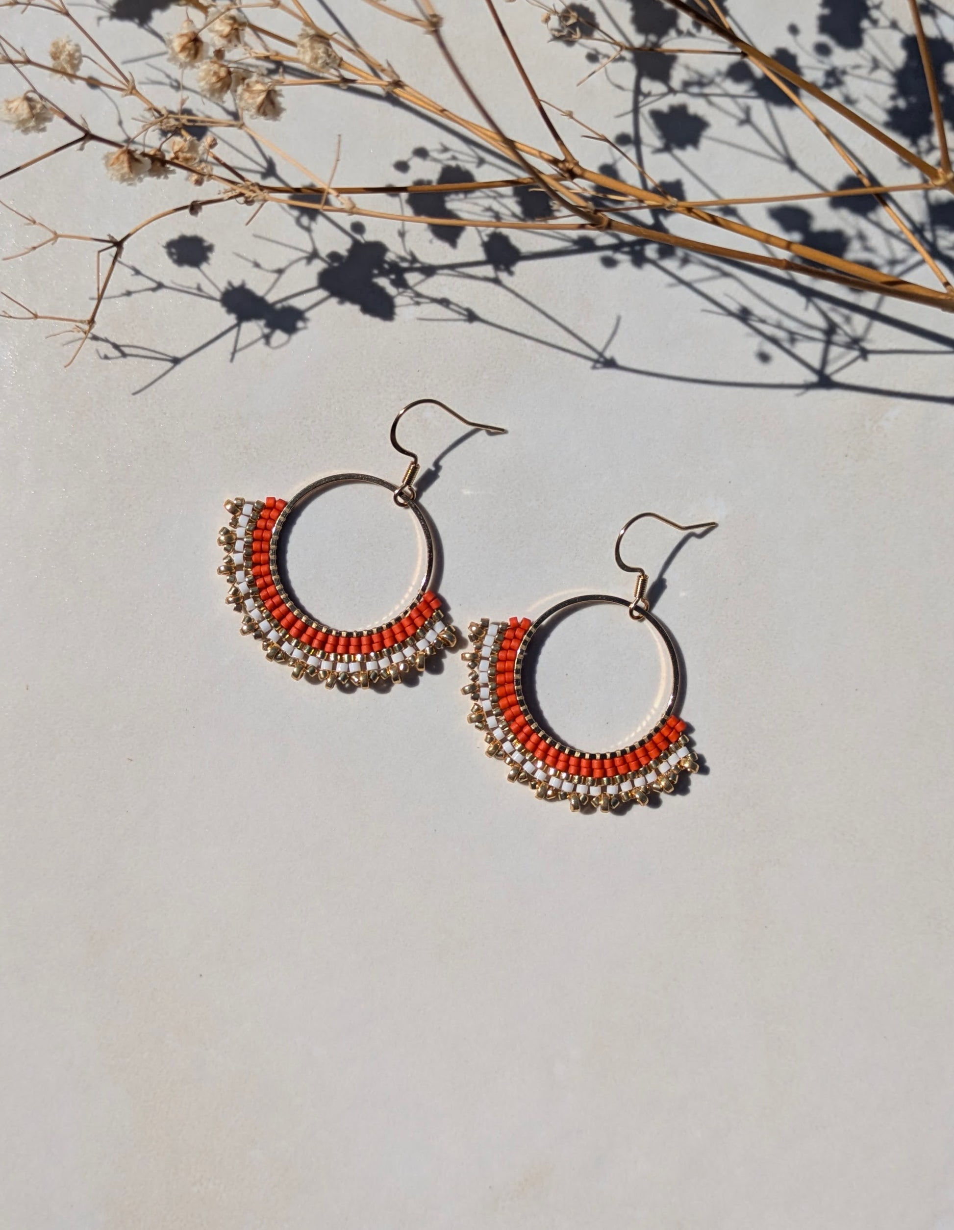 Détail du tissage artisanal des créoles CARLA en perles de verre rouge orangé