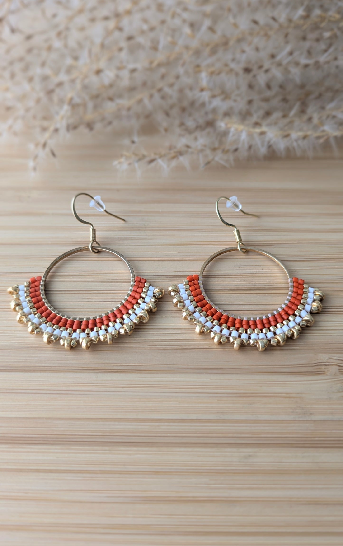 Gros plan sur les perles miyuki rouges et crochets en acier inoxydable doré