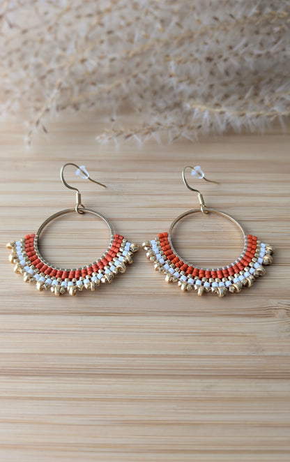 Gros plan sur les perles miyuki rouges et crochets en acier inoxydable doré