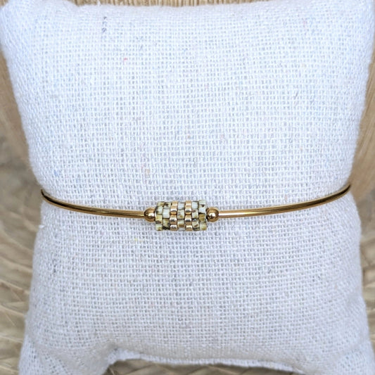 Jonc doré avec perles tissées Yellow Picasso présenté sur un coussin - Ve de face