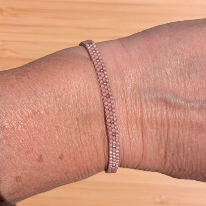 bracelet rose en perles tissées sur un poignet de femme