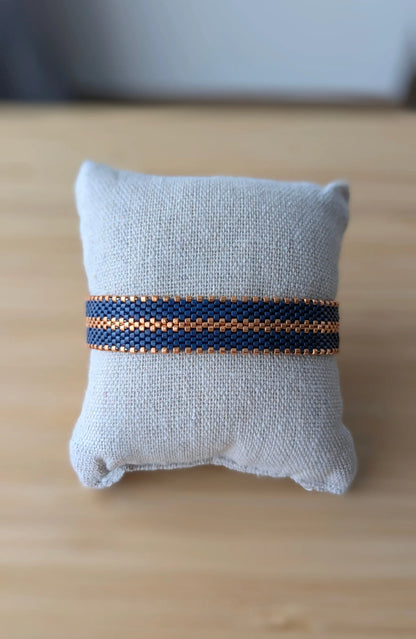 bracelet tissé en perles miyuki bleu marine et cuivrées présenté sur un coussin
