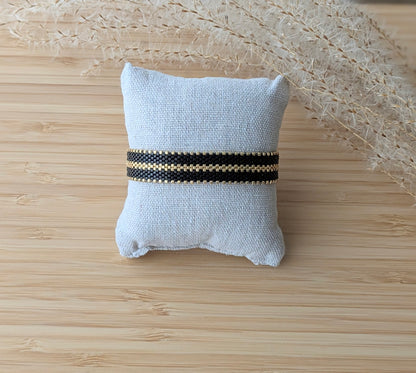 bracelet noir et doré présenté sur coussin- décor bohème