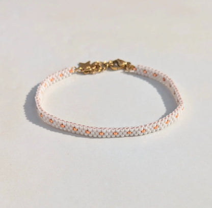 Vue de haut du bracelet artisanal en perles blanches et acier inoxydable doré