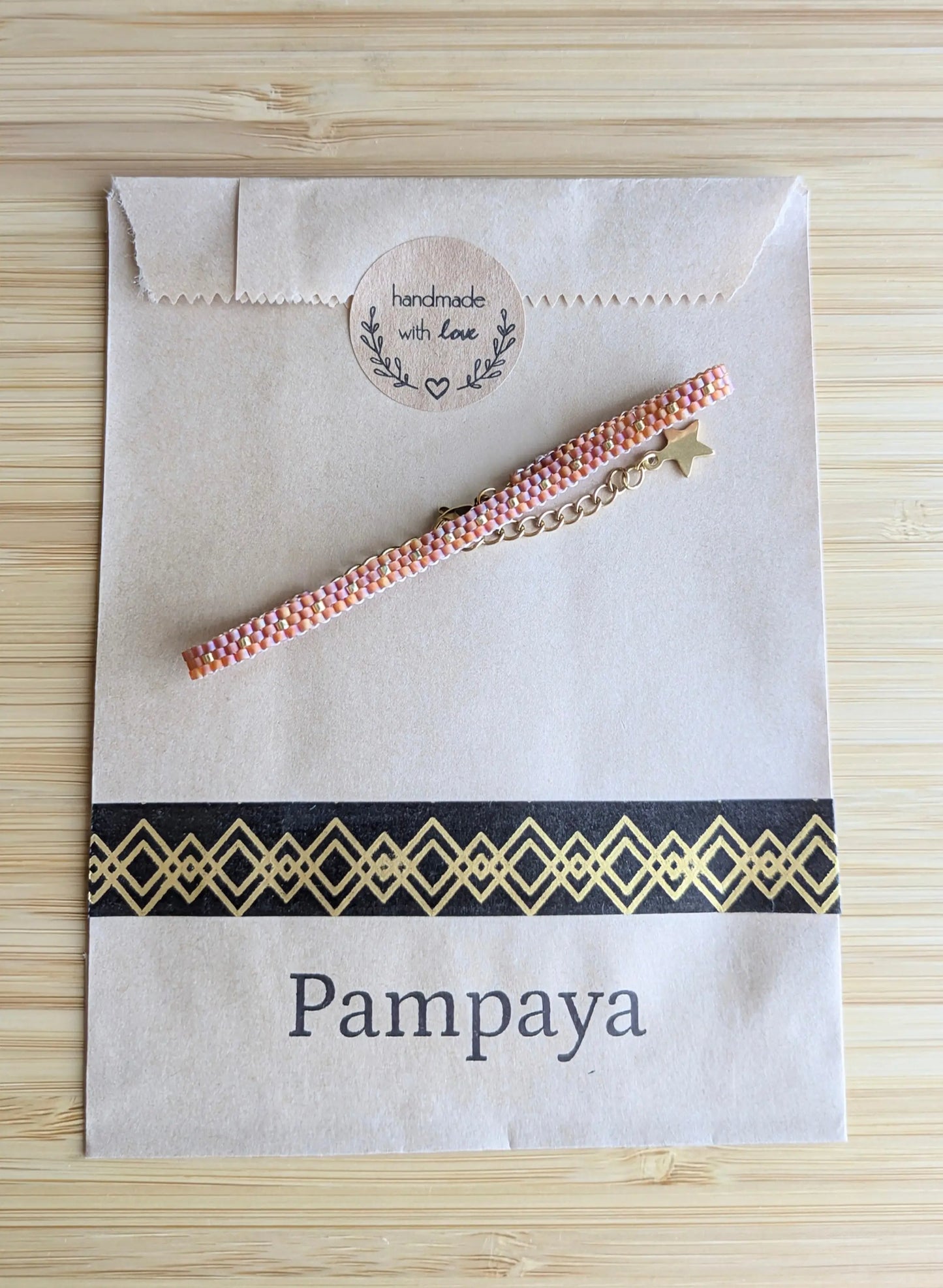 Bracelet tissé fin rouge sur emballage sachet kraft Pampaya avec sticker "Handmade with love"