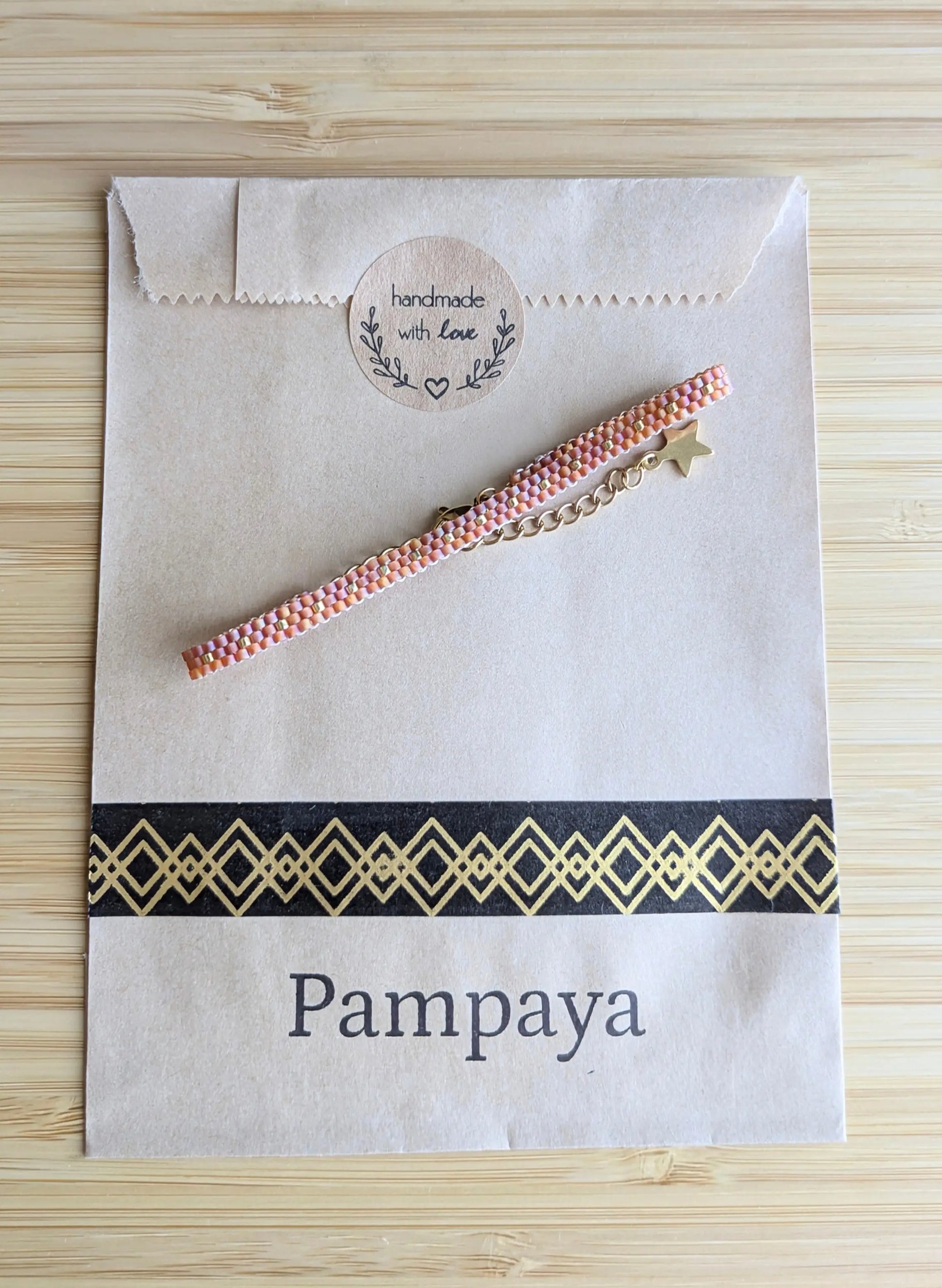 Bracelet tissé fin rouge sur emballage sachet kraft Pampaya avec sticker "Handmade with love"
